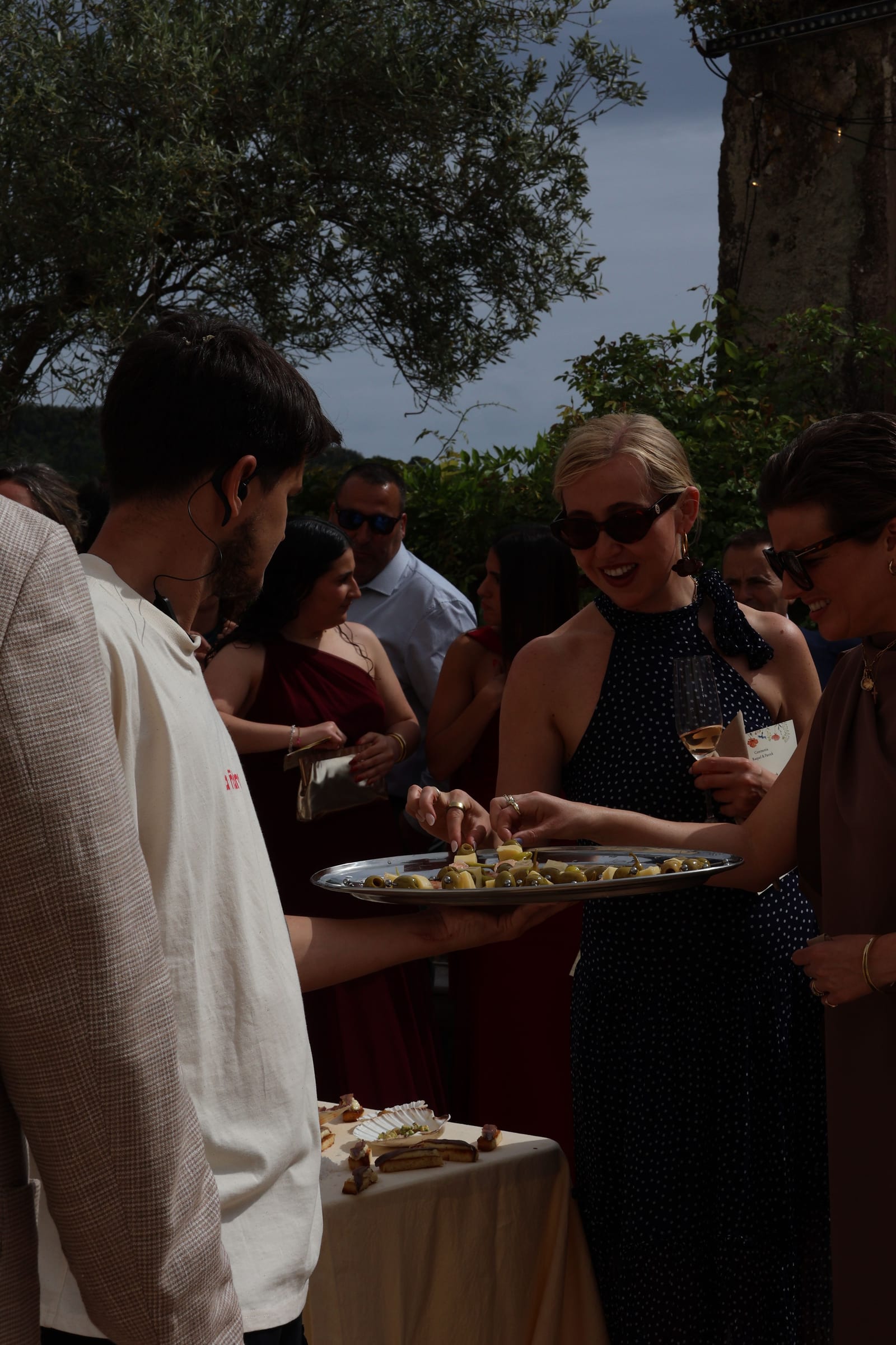 Invitados sirviéndose en un cóctel al aire libre