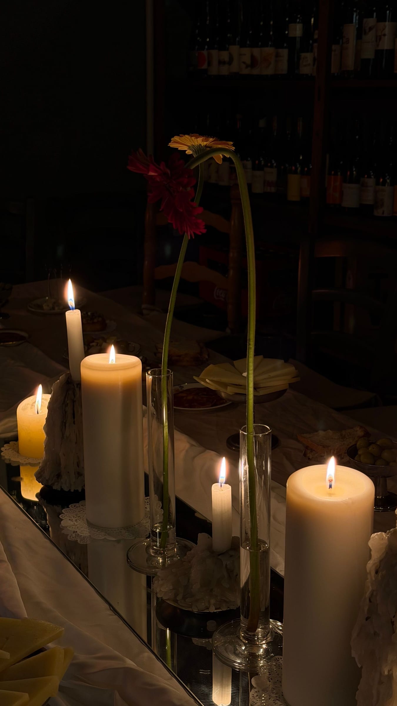 Velas encendidas y flores en una mesa en penumbra