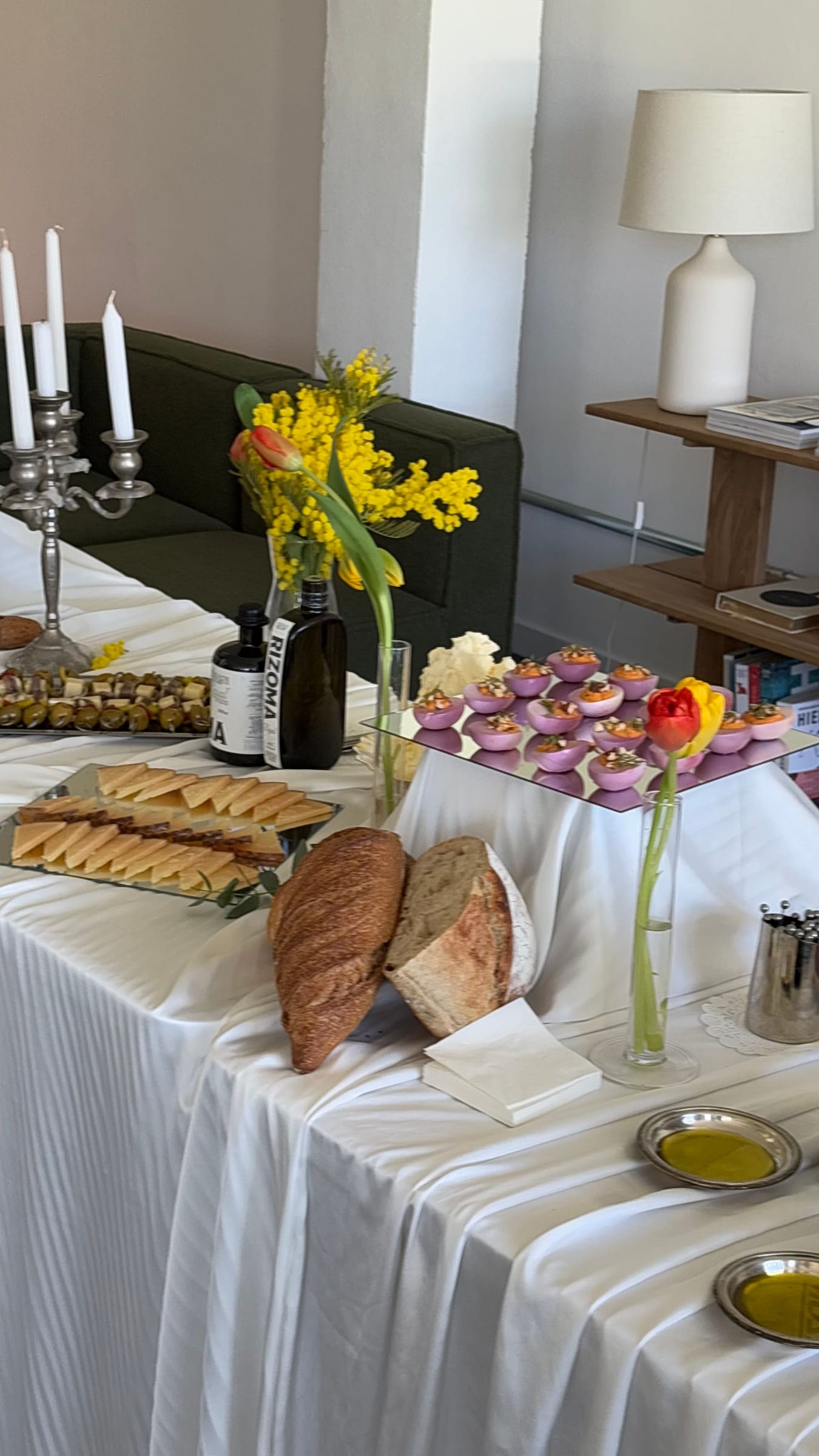 Mesa con velas, flores amarillas y panes