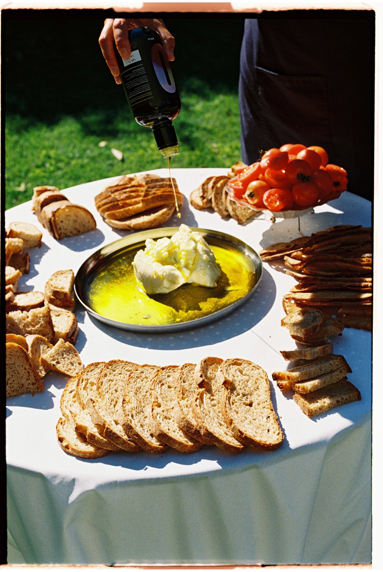 Mesa redonda con panes, aceite y tomates