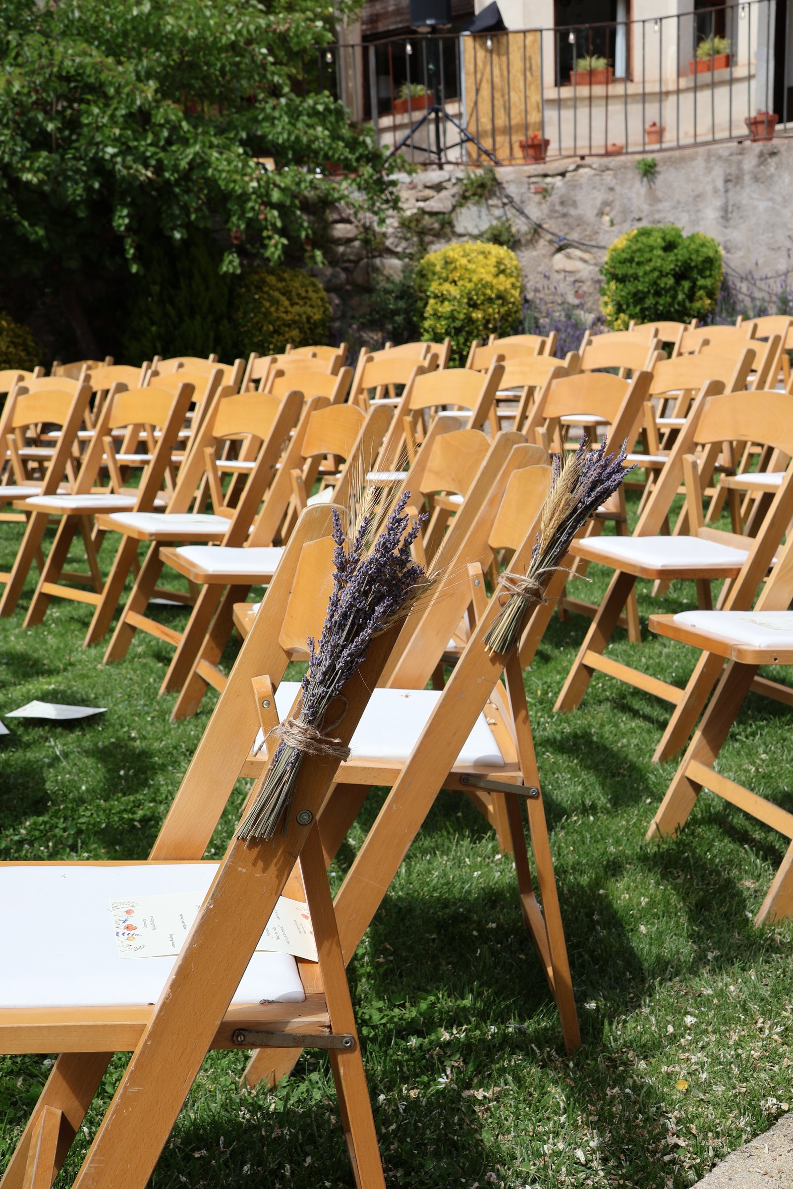 Sillas de madera en el césped con lavanda para la ceremonia