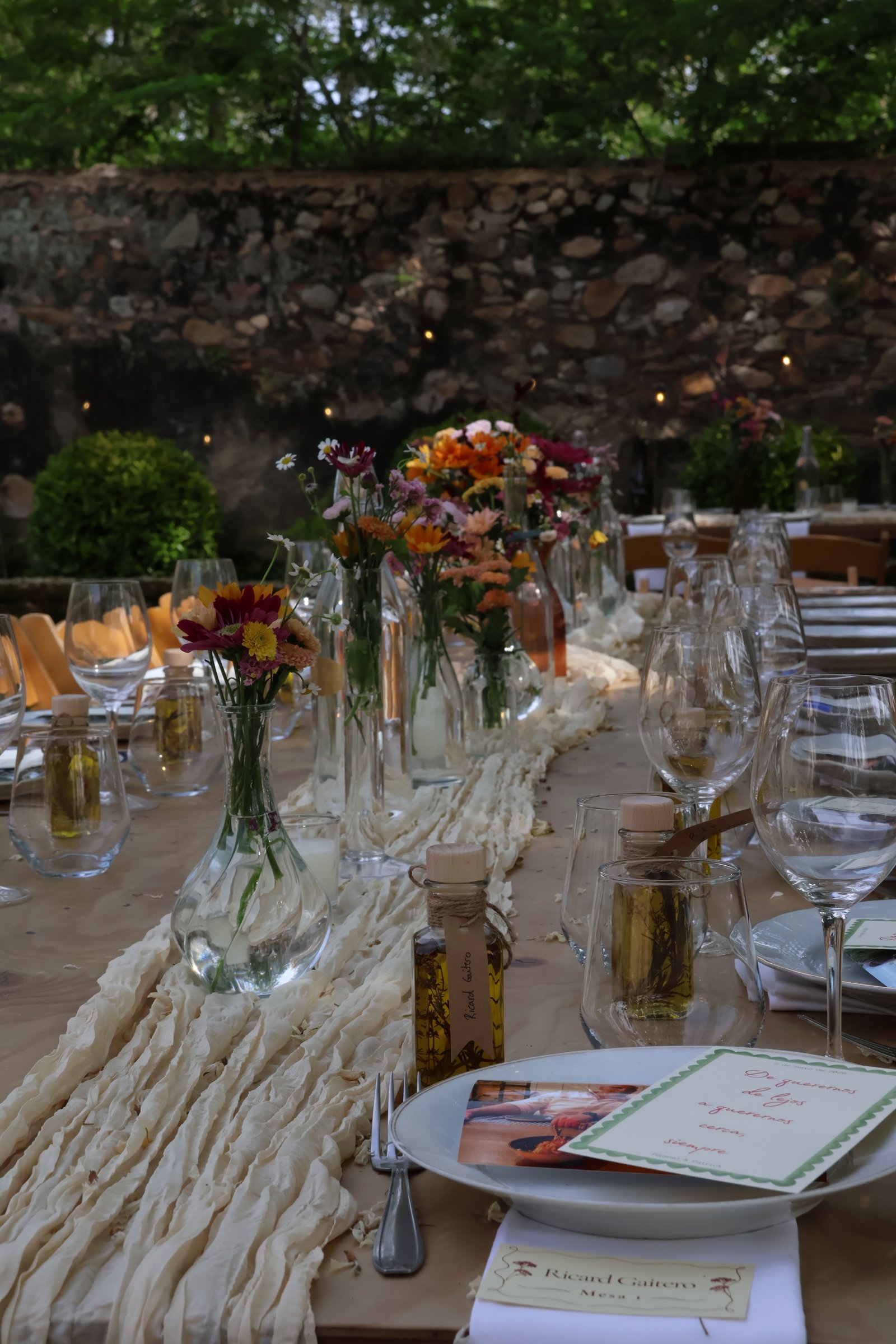 Mesa larga con flores, copas y menús