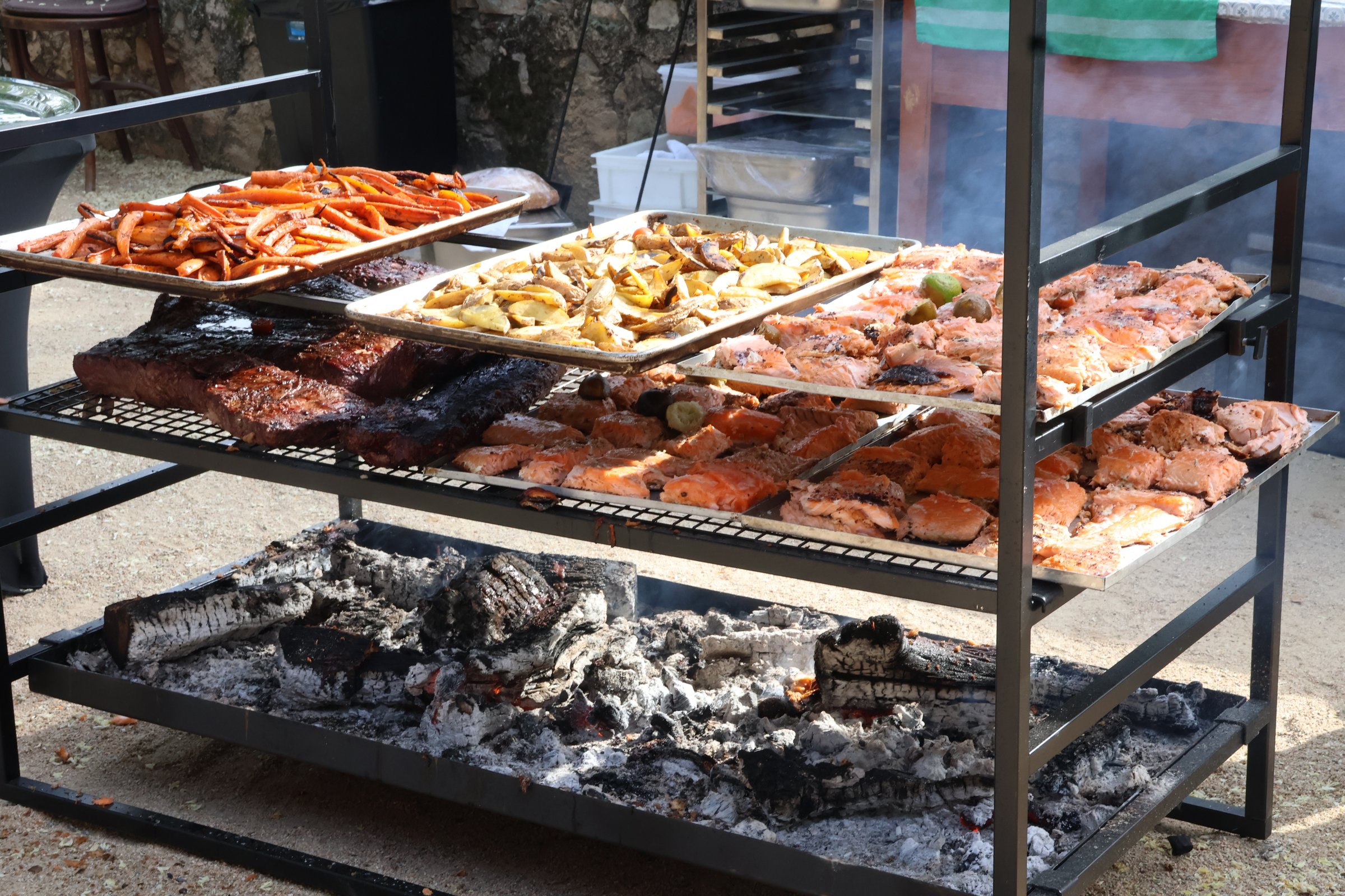 Parrilla con bandejas de carne sobre las brasas