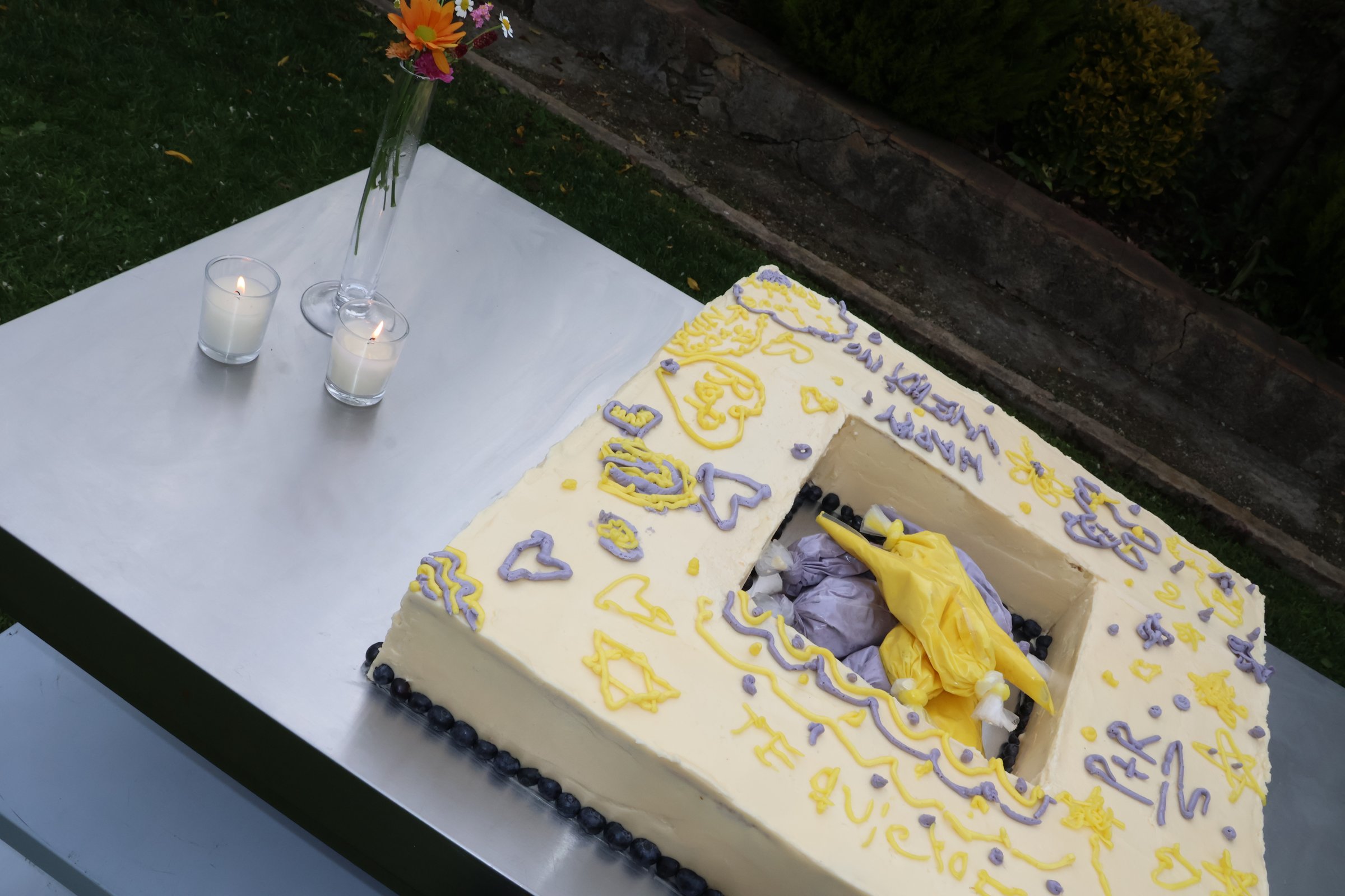 Tarta decorada en amarillo y lila sobre una mesa en el jardín
