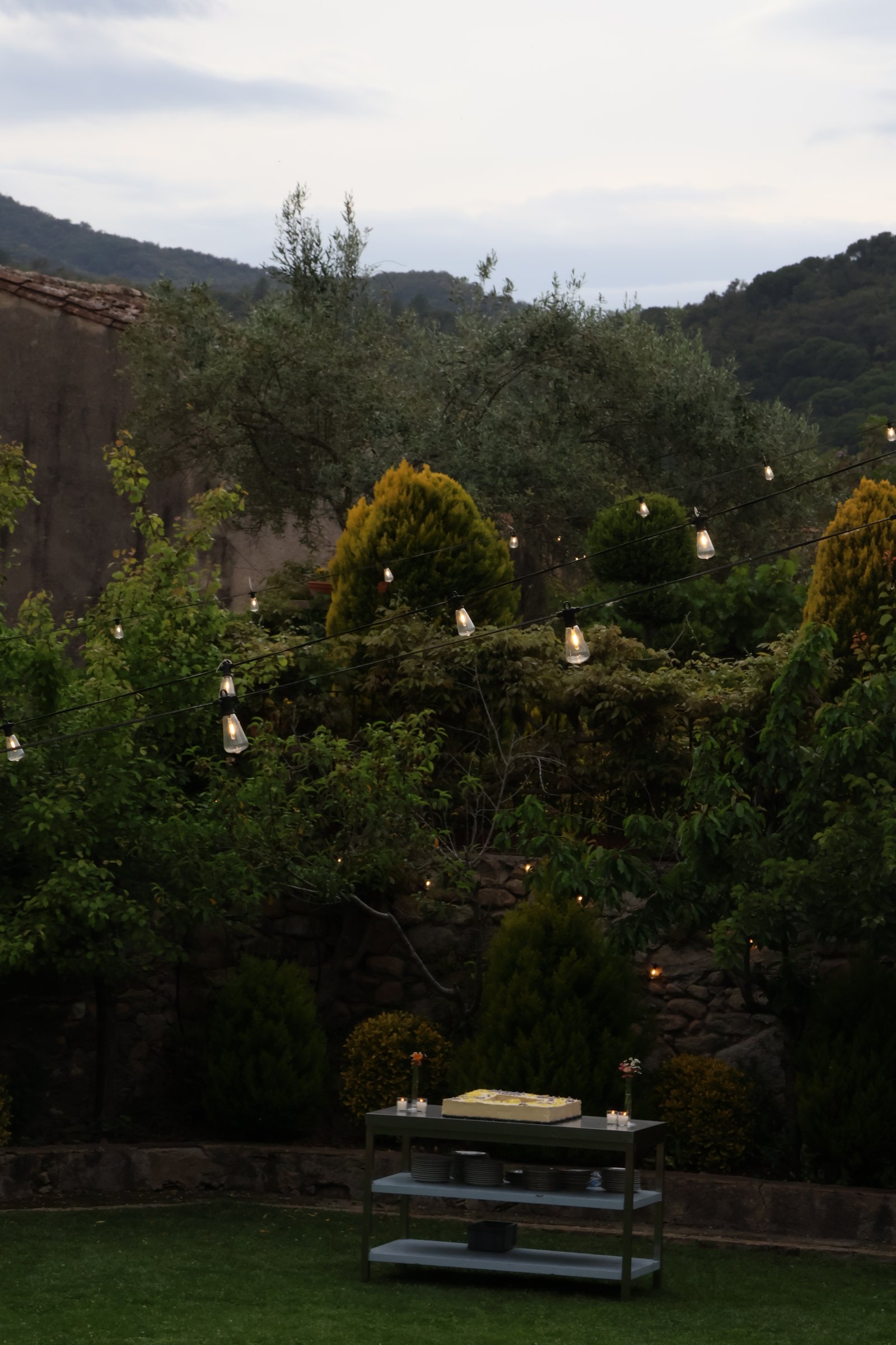 Jardín al anochecer con guirnaldas de luces
