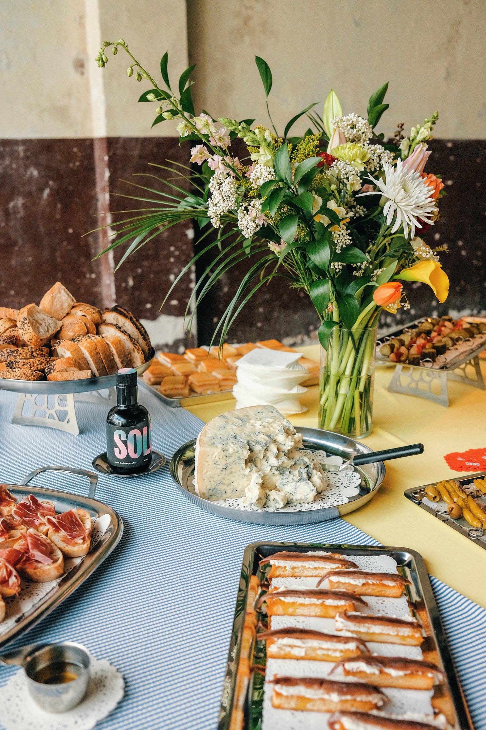 Mesa de bufé con flores, quesos y bandejas