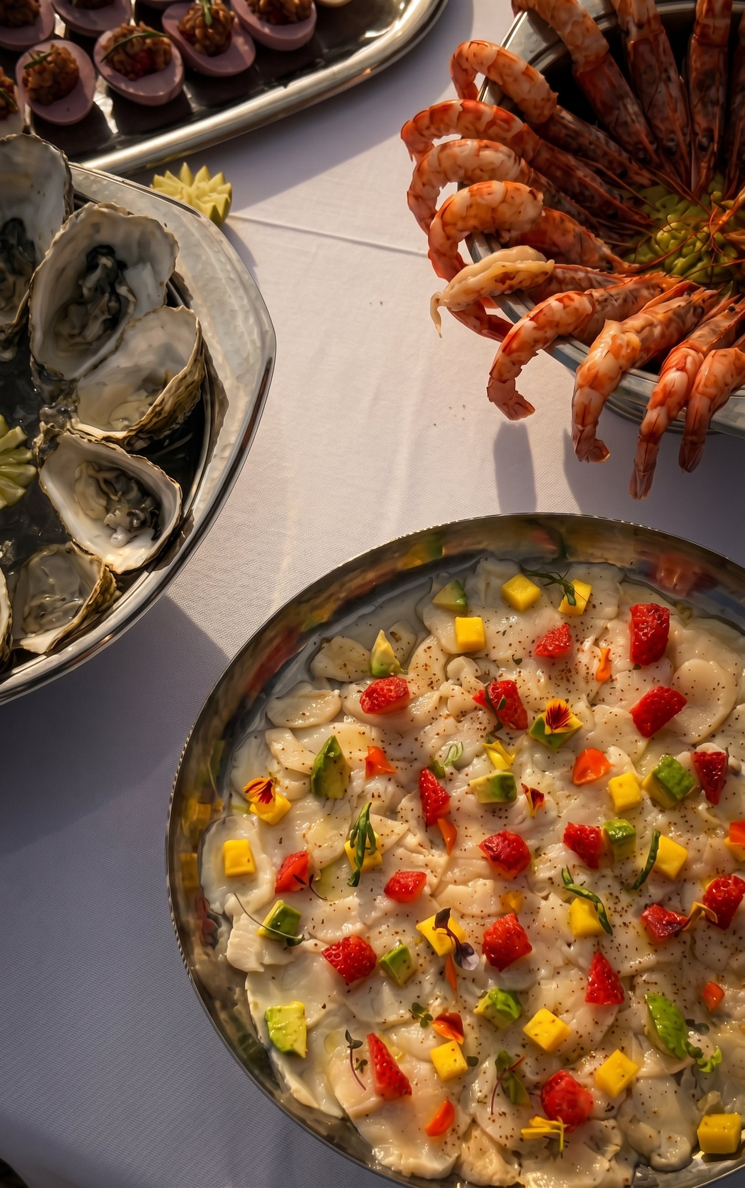 Ostras, gambas y carpaccio de vieiras con fruta, vistos desde arriba